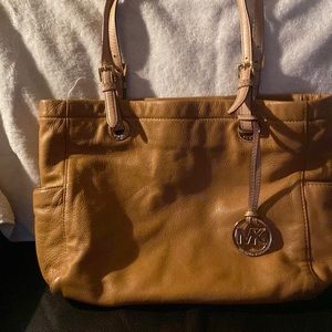 Michael Joe’s tan adjustable straps purse. It has serveral pockets